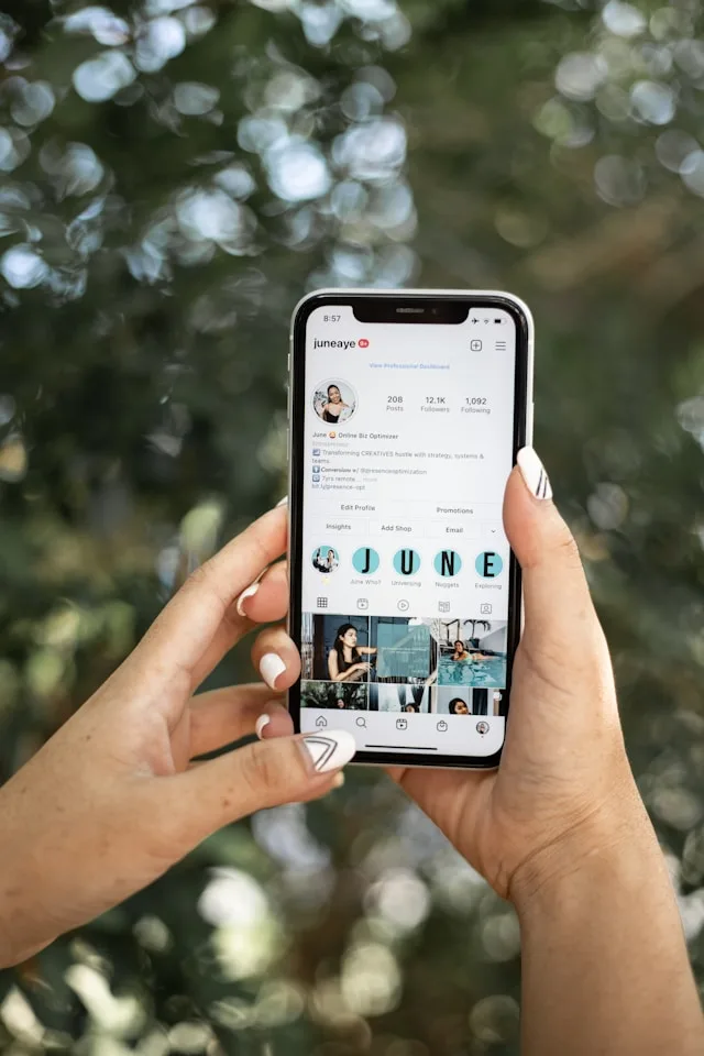 pessoa segurando o celular na mão e analisando como colocar destaques no Instagram além de analisar dados para mídia kit do Instagram